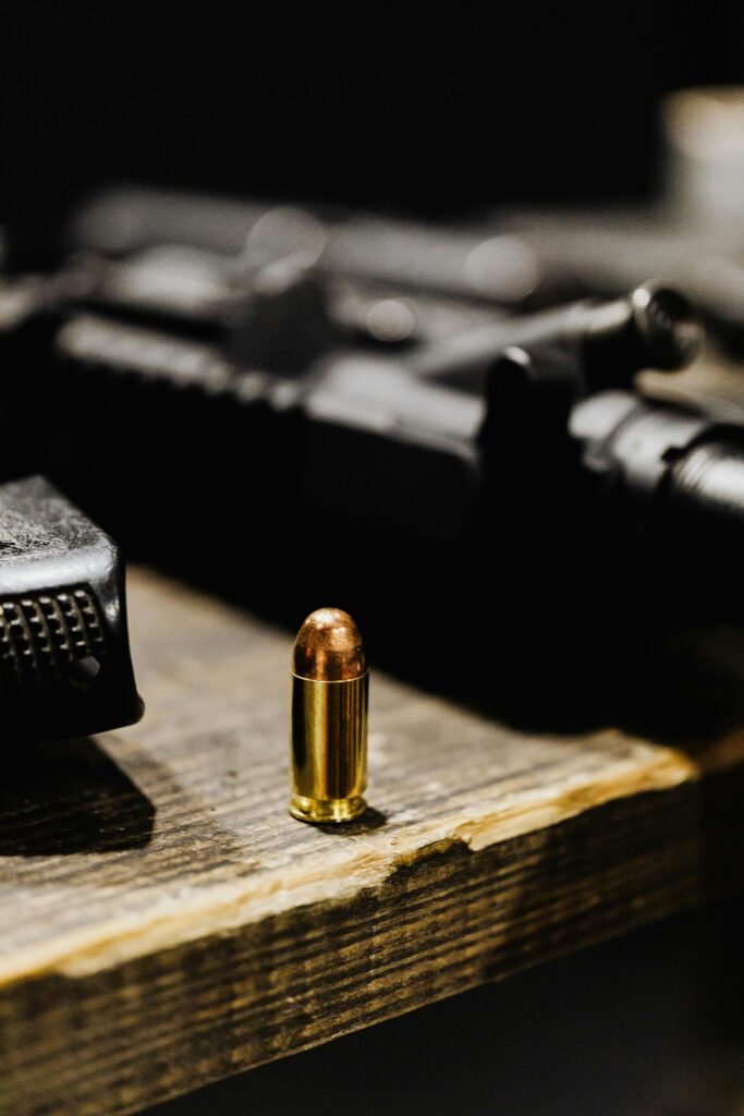 pexels-photo-5202415-5202415 A focused view of a bullet standing upright on a rustic wooden surface.