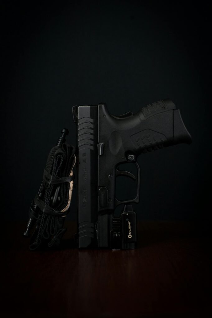 Detailed close-up of a handgun with tactical accessories against a dark backdrop.